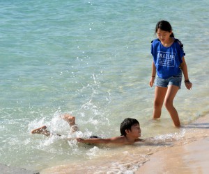 夏を思わせる陽気の中、ビーチで元気よく遊ぶ子供たち＝６日、下地与那覇の前浜ビーチ