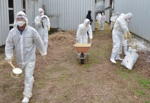 関係者が施設周辺に消毒薬を散布し、鳥インフルエンザの未然防止を図った＝３１日、市内の家きん飼養施設