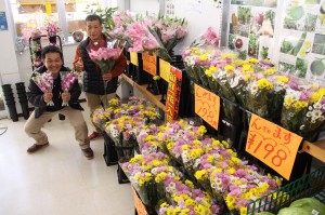 「気軽に花に親しんでほしい」と話す豊里社長（右）と息子の大器さん＝２７日、ワイドー市場内