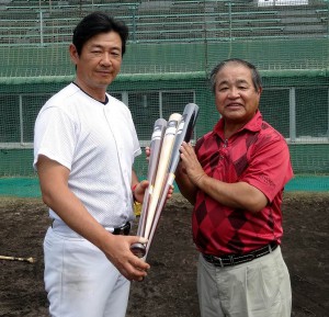宮古島応援団の平良会長にバットを贈る平成国際大野球部の大島監督（左）＝１３日、市民球場