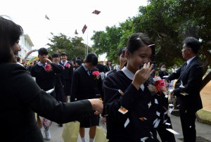 花道で祝福を受ける卒業生。この日は１２校５０２人が学びやに別れを告げた＝１２日、平良中学校