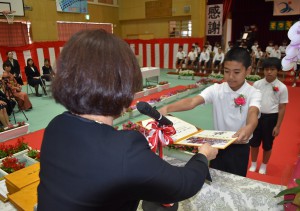 亀川校長（手前左）が一人一人に卒業証書を授与した＝２２日、久松小体育館