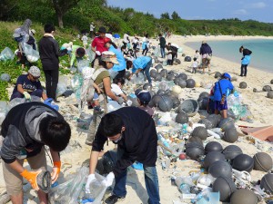砂浜に打ち上げられた漁業用ブイやペットボトルなど大量の漂着ごみを参加者たちが拾い集めた＝５日、高野海岸