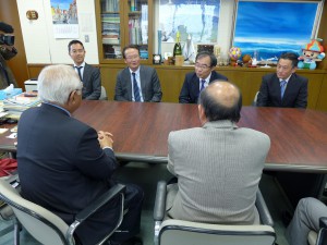 谷澤取締役（奥左から２番目）が今後のスケジュールなどを下地市長と長濱政治副市長に報告した＝９日、市役所平良庁舎