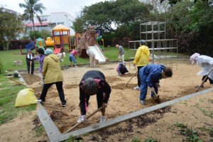 砂場の砂を掘り返して戻す参加者ら＝２２日、平良の盛加越公園