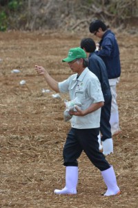 緑肥としてヒマワリの種をまく下地副会長ら＝１８日、伊良部の佐和田地区