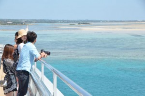 橋の上では、青い海と青い空の絶景に魅了された観光客らがスマホやデジタルカメラで記念撮影をする姿が見られた＝２９日、伊良部大橋