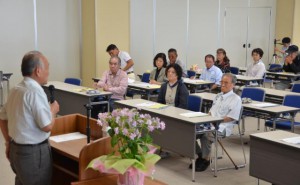 徳田共同代表の講話に聞き入る参加者たち＝１８日、宮古南静園総合棟講堂