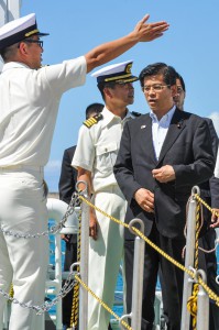宮田船長（左）から説明を受ける石井大臣（右）。中央は久留部長＝２３日、長山港