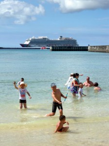 今年最高となる３２・９度を観測。市内ビーチでは外国人観光客も海水浴を楽しんだ。後方は大型クルーズ船＝１２日、パイナガマビーチ