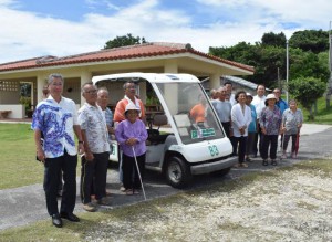 カート贈呈後、沖縄東急会の古井会長（左）は住民と一緒に記念撮影した＝６日、大神島