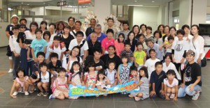 歓迎式で記念撮影をする福島からの家族と宮古島の受け入れメンバーら＝２５日、宮古空港