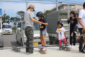 スケートボードの乗り方を教えてもらう初心者の子供たち＝１２日、カママ嶺公園スケートパーク