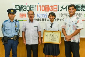 新里部長（中央左）から表彰状を授与された村田さん（同右）、宮國校長（右）と狩俣駐在所の久場良政巡査部長＝１３日、狩俣中学校