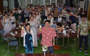 横山裕太さん（手前右）と妻のまつ梨さん（同左）の手作り披露宴は大いに盛り上がった＝１７日、城辺の友利公民館