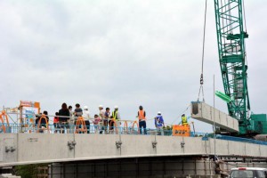 乗瀬橋主桁の架設が始まった。現場には市民らが見学に訪れた＝２５日、伊良部字伊良部