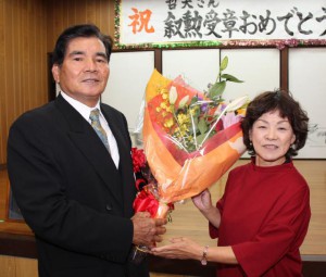 花城公民館長（右）から花束を受け取る荷川取さん＝２５日、福西公民館