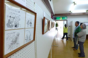 会場には初日から多くの市民が詰め掛け、砂川さんのユニークで批判精神あふれる風刺画を楽しんだ＝５日、市中央公民館