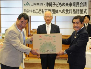 渡名喜代表（左）に目録を贈った末吉会長（右）。中央は浦崎副知事＝１５日、県庁