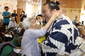 お年寄りたちと笑顔で交流する豊ノ島さん＝１２日、宮古島徳洲会病院通所リハビリテーション事業所