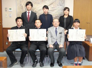 長濱副市長（前列右から２人目）から賞状を受け取った恩川君（前列左）、山里君（同左から２人目）、狩俣さん（同右）＝31日、市役所平良庁舎