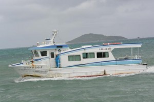大神島（後方に浮かぶ島）と島尻漁港の間を運航する客船「スマヌかりゆす」＝１日、島尻漁港から