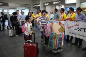 観光協会やホテル関係者が名古屋から初便で訪れた観光客らを歓迎幕で温かく出迎えた＝25日、宮古空港