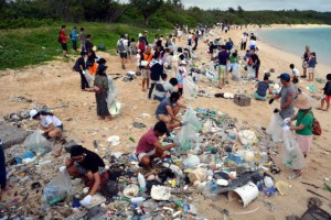 砂浜に流れ着いた大量のごみを拾い集める市民。３６０人以上が参加して環境の美化に努めた＝４日、高野海岸