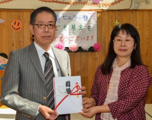 田代部長（左）から上地理事長に基金が贈呈された＝23日、上野児童館