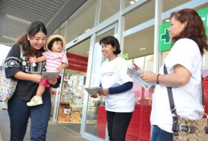 子連れの買い物客らにチラシを配布しはしかに対する正しい知識と予防策の徹底を呼び掛けた＝27日、市内の大型スーパー