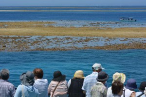 八重干瀬を形成するサンゴ礁の一つ「キジャカ干瀬」を観賞する観光客ら＝16日、客船「モンブラン」から