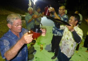 月明かりの下で「ヤッカ、ヤッカ」のはやしを島全体に響かせ、角皿で神酒を飲んだ＝４月30日深夜、パイジュニの祭場