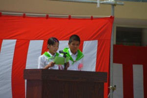 第69回県植樹祭で大会決議を読み上げる石川君と宜野座さん＝１９日、宜野座村