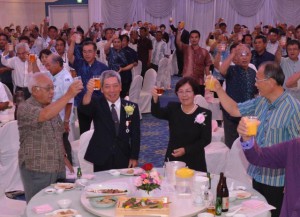 川満長英さん（中央左）の叙勲受章を祝い祝杯を挙げる関係者＝７日、市内ホテル