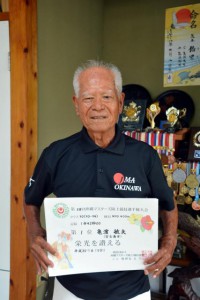 沖縄マスターズ陸上で３冠を飾った亀濱敏夫さん。１１年連続の偉業を達成した＝１２日、平良西里の自宅で