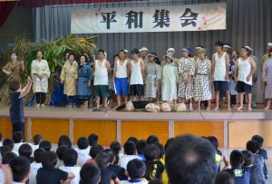 生徒と地域の人たちが熱のこもった演技で平和の大切さをアピールした＝22日、西原公民館