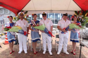 ミス宮古島から花束を受け取るゴシュロイ副船長（左から２人目）ら＝14日、平良港ターミナルビル前