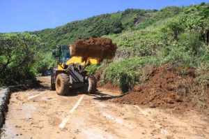 重機を使い道路に流れた土砂を除去する作業が行われた＝７日午前、吉野海岸