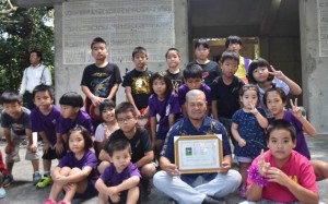 川満自治会長が特別住民票を手に子どもたちと一緒に記念撮影した＝23日、伊良部の佐和田ユークイ