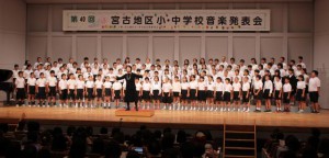 小学校の部オープニングで全体合唱を披露する小学生たち＝23日、マティダ市民劇場