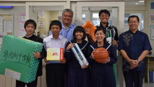 狩俣さん（後列左から１人目）から各部活の主将に用具が贈られた＝20日、多良間中学校