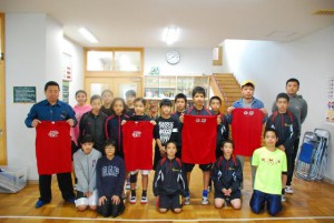 花城会長（左）から選手たちにユニホームが贈られた＝２２日、鏡原小学校