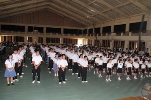 始業式で初めてみんなで校歌を歌う児童生徒ら＝８日、伊良部島小学校・中学校体育館