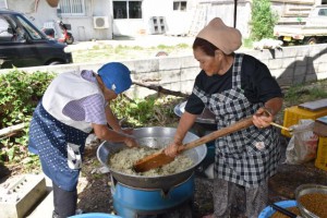 米を炊き発酵させた麦麹を混ぜ合わせる女性ら＝19日、字塩川