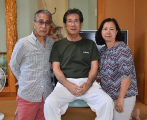 長兄の漢那紀光さん（中央）と３年ぶりに再会した漢那国浩さん（左）と妻のシェリーさん＝23日、佐良浜の実家