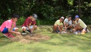 施肥作業を行う下地小緑の少年団の子どもたち。12月の育樹祭では県を代表して緑化活動を発表する＝６日、県立宮古青少年の家