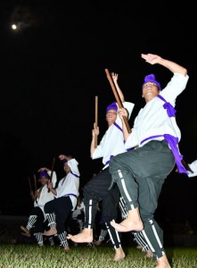 満月の下、勇壮な棒踊りを披露する男性＝13日、上野野原の野原公民館