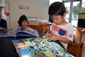 きょうから読書週間。未来創造センターで絵本を楽しむ子どもたち＝26日、平良東仲宗根