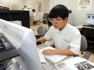パソコンを使い新聞製作体験に挑戦する立津さん＝13日、宮古毎日新聞社