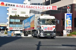 初荷を載せて出発するトラック＝３日、浦添市のオリオンビール本社